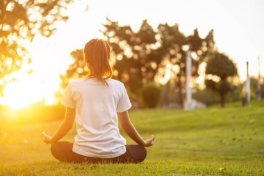 Güzel Asyalı kadın parkta yoga egzersizi yapıyor.