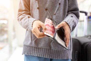 Siyah duvardaki banknotları sayan ya da kontrol eden Asyalı genç turist