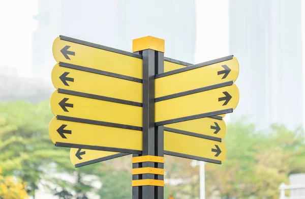 Arrow yellow sign at the road in the big city — Stock Photo, Image