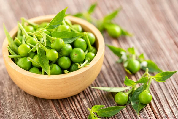 Green circle chilli or cherry peppers in wood bowl on table plan — Stock Photo, Image