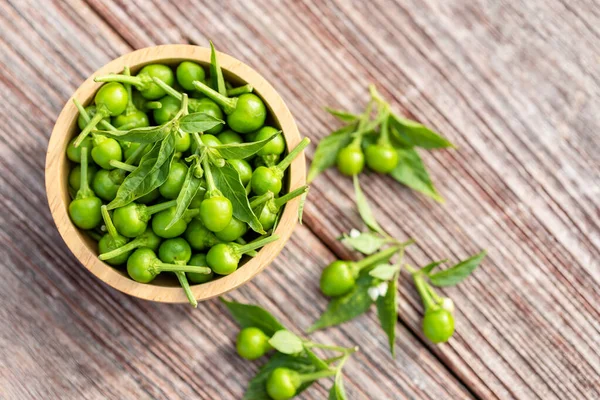 Green circle chilli or cherry peppers in wood bowl on table plan — Stock Photo, Image