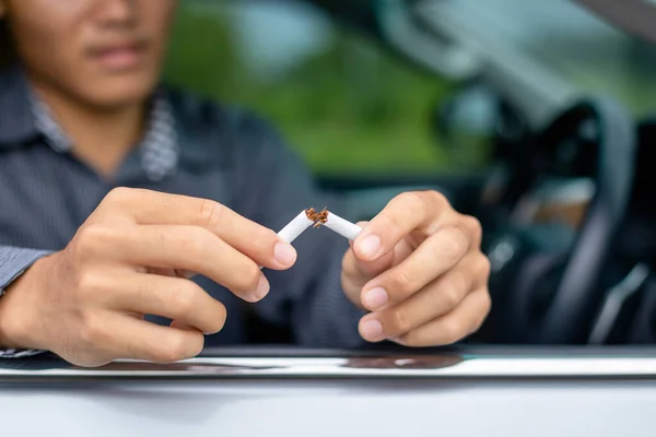 Joven sentado en el coche y destruir el cigarrillo a mano. Detente. — Foto de Stock