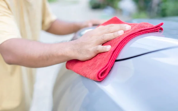 Mann benutzt rotes Tuch, um Karosserie des Geländewagens zu reinigen. Reinigung oder war — Stockfoto