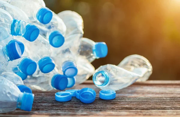 Heap of empty clear plastic water bottle on wooden plank. — Stock Photo, Image