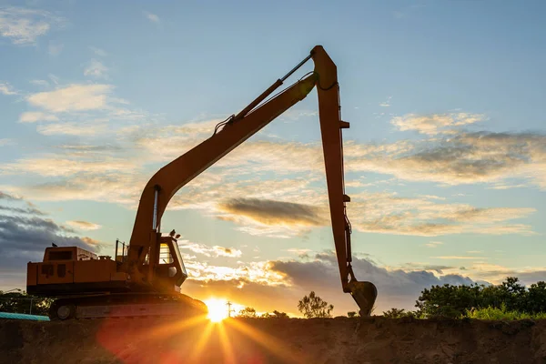 Silhouette de grande excavatrice à chenilles creusant le sol sur place — Photo