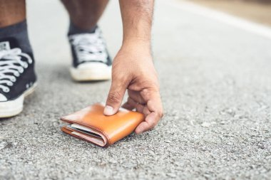 Asyalı adam turistlerin ilgisini çekerken kahverengi cüzdanını kaybetti. Cüzdan konseptini kaybetmek. Cüzdana odaklan.