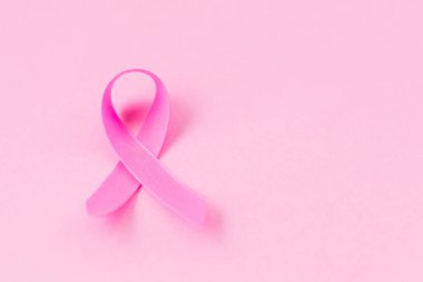 Göğüs kanseri kavramı: Pembe arka planda göğüs kanseri kampanyasının üst görünüm pembe kurdele sembolü