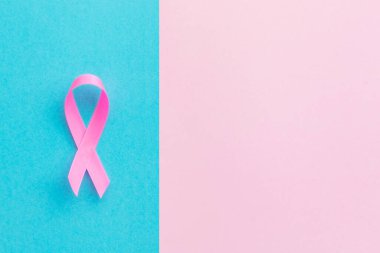 Göğüs kanseri kavramı: Pembe ve parlak mavi arkaplan üzerine yürütülen göğüs kanseri kampanyasının üst görünüm pembe kurdele sembolü