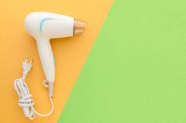 Üst görünüm yeni beyaz saç kurutma makinesi pembe arkaplan üzerinde metin veya tasarım için kopyalama alanı ile