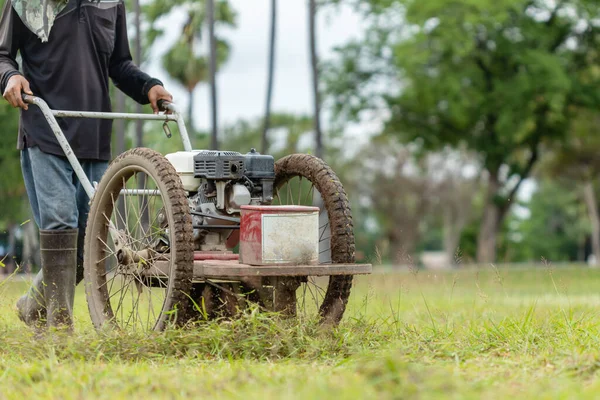 公共の庭で機械で草を刈るタイ人労働者 — ストック写真