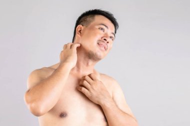 Sağlık hizmetleri veya Kıymık veya Tinea Cruris konsepti: Vücudunu tırmalamak için el kullanan insanların portresi. Gri arkaplanda stüdyo çekimi