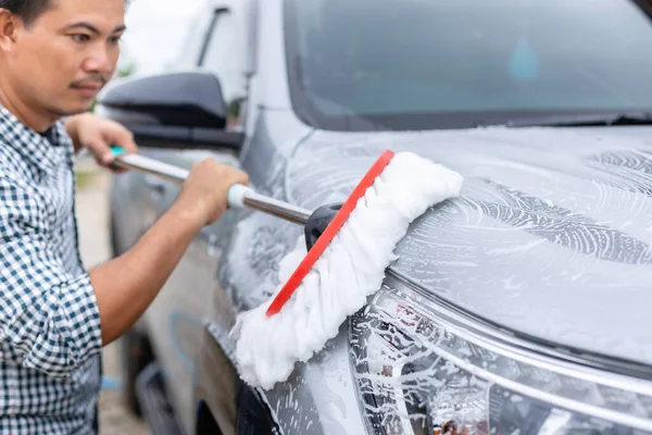 Asyalı Adam Dışarıda Arabayı Yıkamak Için Sabunla Beyaz Paspas Kullanıyor — Stok fotoğraf