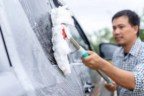 Asyalı Adam Dışarıda Arabayı Yıkamak Için Sabunla Beyaz Paspas Kullanıyor — Stok fotoğraf