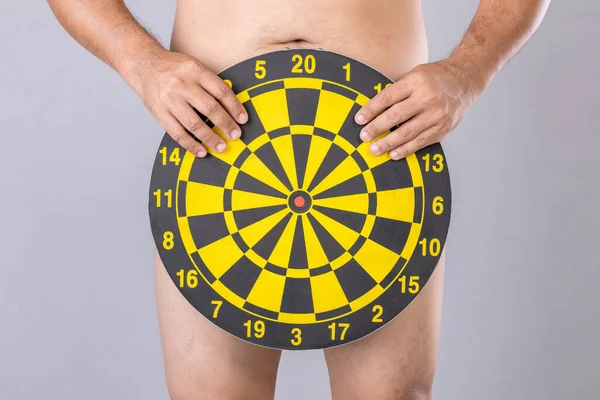 Man Holding Yellow Dartboard Hide His Penis Position Studio Shot Stockfoto