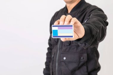 Siyah ceketli bir portre sürücüsü elinde boş Tayland ehliyeti var. Tayland 'da 400 cc' den fazla motosiklet için özellikle ehliyet gerekiyor. Stüdyo çekimi gri arkaplanda izole edildi
