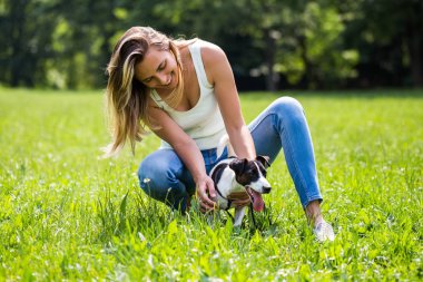 Güzel bir kadın onun sevimli köpek Jack Russell Terrier ile doğada zaman geçirmekten hoşlanıyor.
