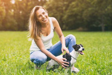 Güzel kadın köpeğini Jack Russell Terrier doğada penye. Görüntü kasten tonda.