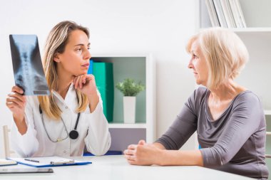 Kadın doktor x-ray görüntü üst düzey kadın hastasını gösterilen .