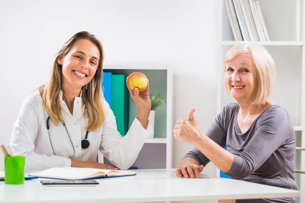 Female Doctor Giving Advice Eating Healthy Food Her Senior Woman — Stock Photo, Image