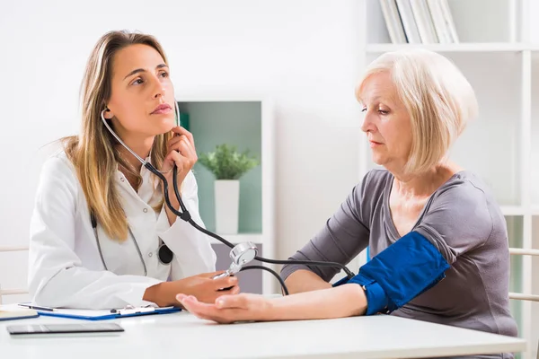 Female Doctor Measuring Blood Pressure Her Senior Patient Doctor Office — Stock Photo, Image
