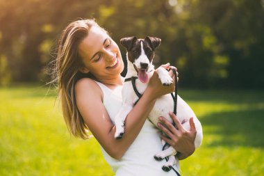 Güzel bir kadın onun sevimli köpek ile doğada zaman geçirmekten hoşlanıyor, Jack Russell Terrier.Image kasıtlı olarak tonda.