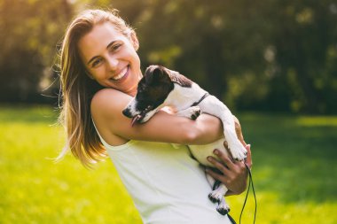 Güzel bir kadın onun sevimli köpek ile doğada zaman geçirmekten hoşlanıyor, Jack Russell Terrier.Image kasıtlı olarak tonda.