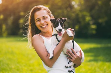 Güzel bir kadın onun sevimli köpek ile doğada zaman geçirmekten hoşlanıyor, Jack Russell Terrier.Image kasıtlı olarak tonda.