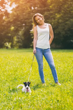 Güzel kadın doğada onun sevimli köpek Jack Russell Terrier ile zaman geçirmekten hoşlanıyor. Görüntü kasten tonda.