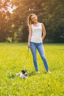 Güzel kadın doğada onun sevimli köpek Jack Russell Terrier ile zaman geçirmekten hoşlanıyor. Görüntü kasten tonda.