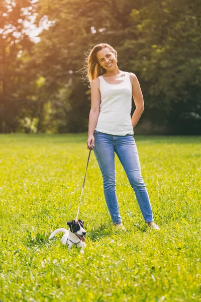 Güzel kadın doğada onun sevimli köpek Jack Russell Terrier ile zaman geçirmekten hoşlanıyor. Görüntü kasten tonda.