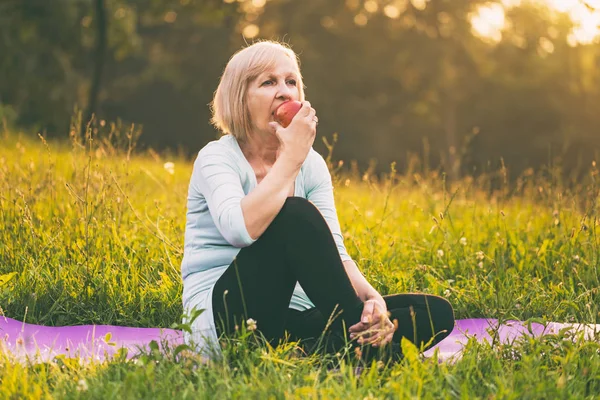 Aktiv Senior Kvinna Äta Äpple Efter Träning Bilden Avsiktligt Tonas — Stockfoto