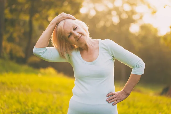 Sporty senior woman exercising outdoor.Image is intentionally toned.