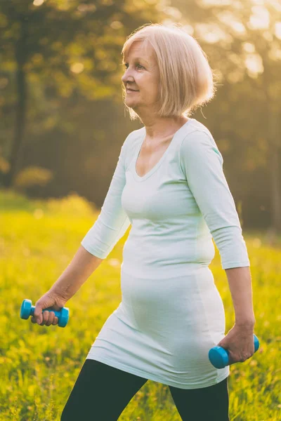 Sportieve Senior Vrouw Oefenen Met Gewichten Buiten Afbeelding Opzettelijk Afgezwakt — Stockfoto