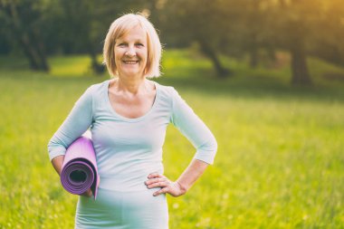 Mat doğada tutan sportif üst düzey kadın portresi. Görüntü kasten tonda.