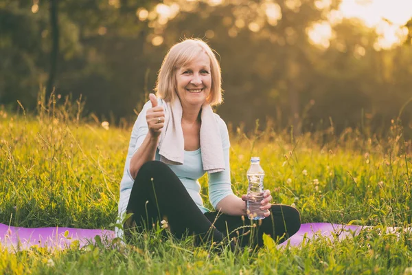 Actieve Senior Vrouw Drinkwater Duim Opdagen Tijdens Oefening Afbeelding Opzettelijk — Stockfoto