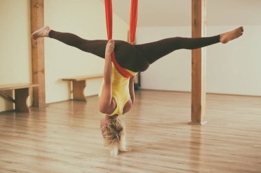 Kadın fitness Studio hava yoga yapıyor. Görüntü kasten tonda.