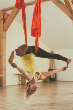 Kadın fitness Studio hava yoga yapıyor. Görüntü kasten tonda.