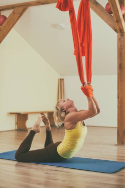 Kadın fitness Studio hava yoga yapıyor. Görüntü kasten tonda.