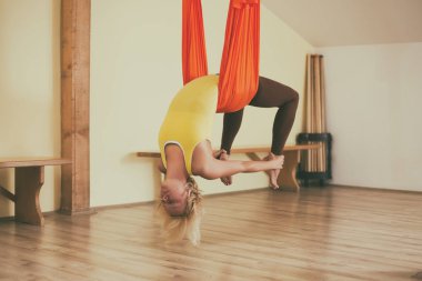 Kadın fitness Studio hava yoga yapıyor. Görüntü kasten tonda.