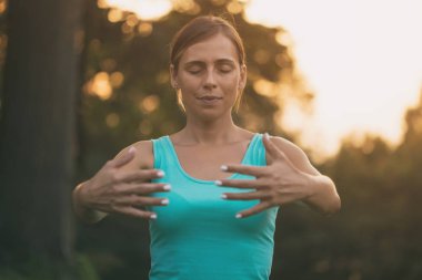 Güzel kadın doğada Tai Chi egzersiz sahiptir. Görüntü kasten tonda.