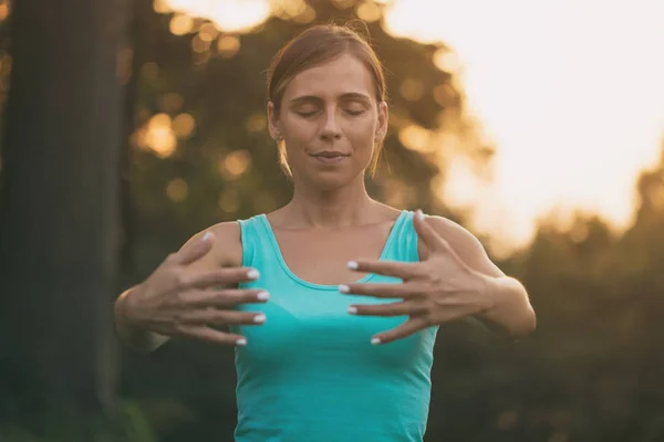 Güzel kadın doğada Tai Chi egzersiz sahiptir. Görüntü kasten tonda.