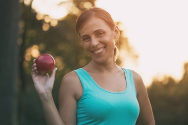 Egzersiz sonrası güzel sportif kadın yeme elma. Görüntü kasten tonda.
