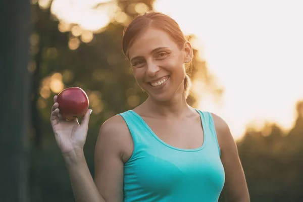 美丽运动的女人吃苹果后运动 图像是故意色调 — 图库照片
