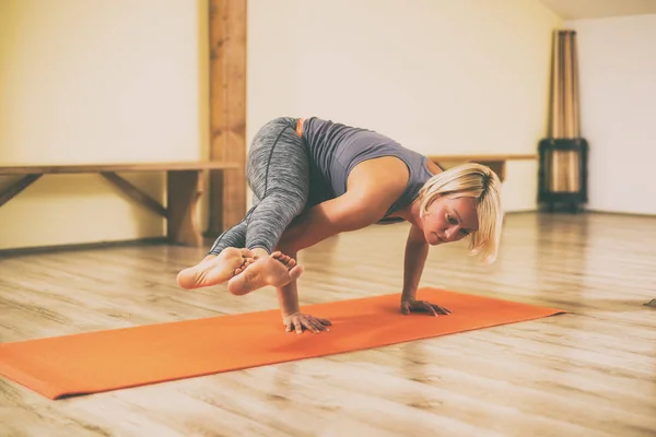 妇女在工作室做瑜伽 Astavakrasana 八角姿势 图像是故意色调 — 图库照片