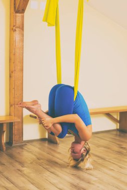 Kadın fitness Studio hava yoga yapıyor. Görüntü kasten tonda.