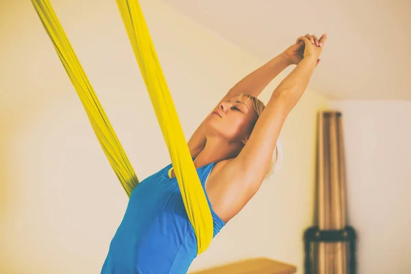 在健身室做空中瑜伽的女人 图像是故意色调 — 图库照片