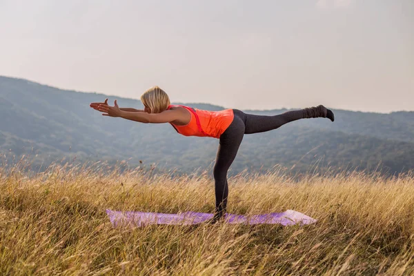 在大自然中做瑜伽的美丽的女人 Virabhadrasana Iii 勇士姿势 Iii 图像是故意色调 — 图库照片