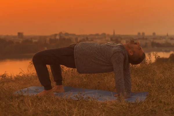 Man Doet Yoga Zonsondergang Met Uitzicht Stad Bridge Pose Getinte — Stockfoto