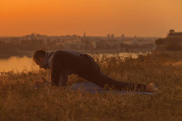 Man Gör Yoga Solnedgången Med Utsikt Över Staden Tonad Bild — Stockfoto