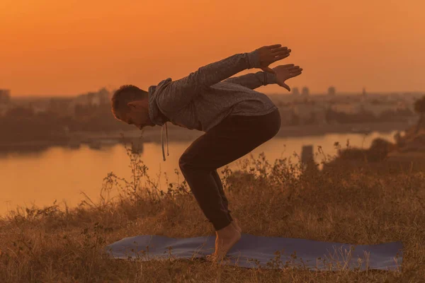 Man Gör Yoga Solnedgången Med Utsikt Över Staden Tonad Bild — Stockfoto